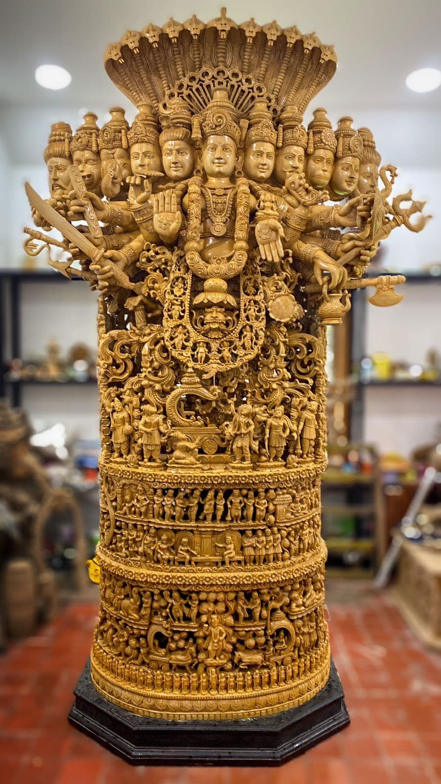 Detailed view of the eleven celestial faces of Mahavishnu on the Viswaroopam wood sculpture