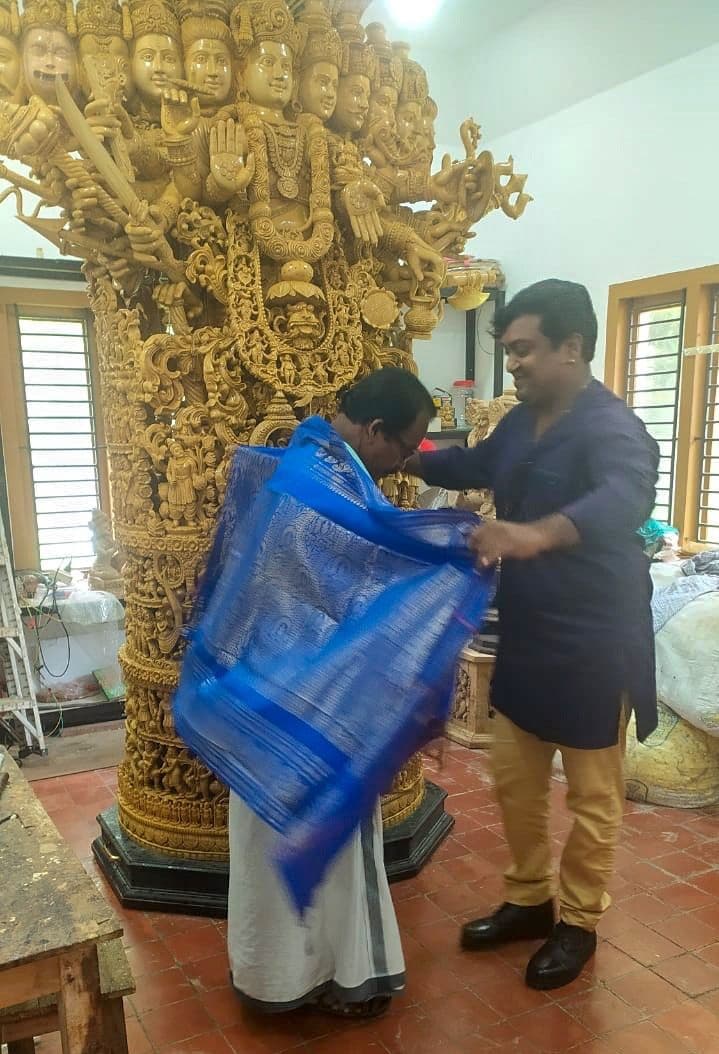 Master Artisan Shri Nagappan being draped in ceremonial silk ponnada before the Viswaroopam sculpture
